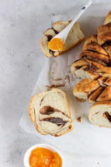 Slices of homemade cinnamon babka or swirl brioche bread. Cinnamon roll bread. Povitica: traditional Polish sweet bread. Light grey background.