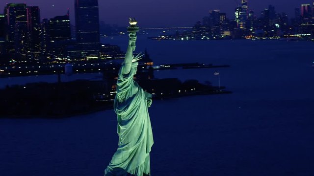 Aerial view of the Statue of Liberty at night. Manhattan and New Jersey skyline. New York City, United States. Shot from a helicopter.