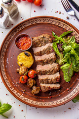 Baked veal served with grilled vegetables, mushrooms and chili sauce, restaurant dish, Top view, Vertical orientation