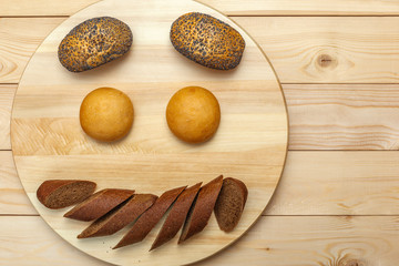 Buns and sliced black bread on a wooden background