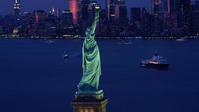 Aerial view of the Statue of Liberty at dusk. Manhattan and New Jersey skyline. New York City, United States. Shot from a helicopter. 