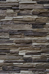 Fasing stone wall of natural stones. Rustic stone wall covering with natural stones.