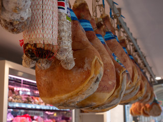 prosciutto (hams) and salami displayed in a traditional butcher shop