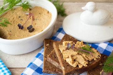 Chicken or duck pate in vintage ceramic white bowl or ramekin and baguette slices