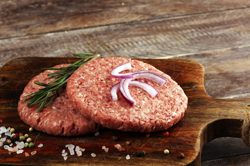 raw patty for angus burger on wooden cutting board. patty for burger