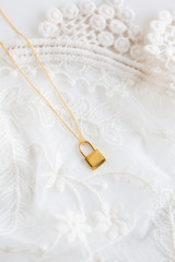 Gold lock necklace on lace