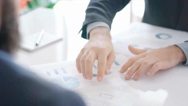 Coworkers discussing in the future of their company over several charts and graphs. Business meeting. All charts created and designed by me.  Lorem Ipsum texts.