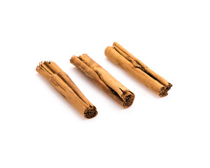Studio shot three raw dried organic cinnamon sticks isolated on white