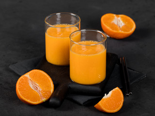 Tangerine smoothie in a glass on a dark background