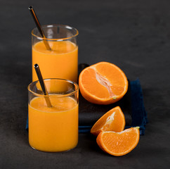 Tangerine smoothie in a glass on a dark background