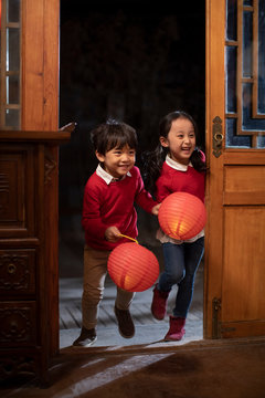 Happy sibling holding Chinese lanterns
