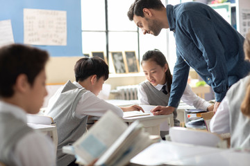 Young teacher helping students in classroom