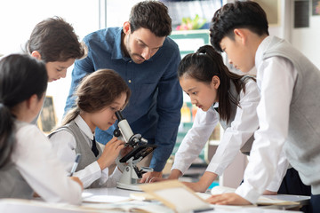 Students using microscope in classroom
