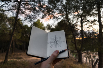 Crop traveler drawing compass on nature