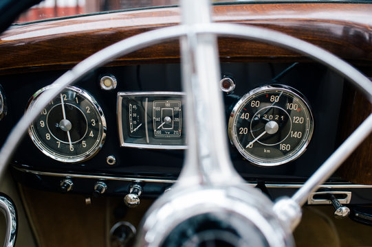 Fragment of metal steering wheel and dashboard of old classical automobile