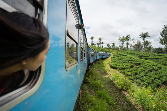 Resting Asian female taking train along green plants
