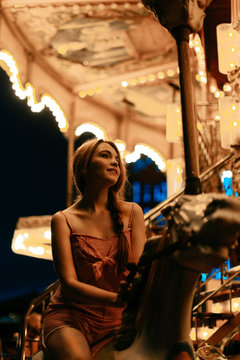 Millennial woman riding carousel horse