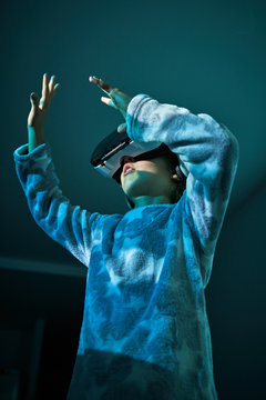 Child wearing virtual glasses at home with colored light effects