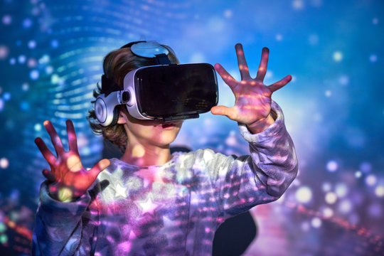 Child wearing virtual glasses at home with colored light effects