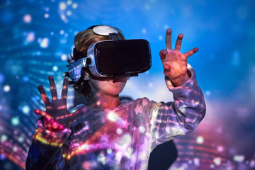 Child wearing virtual glasses at home with colored light effects