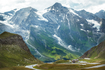 Green mountain ridge covered with snow on overcast day in Austria