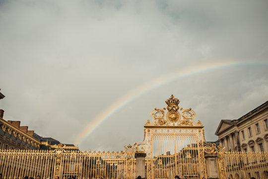 From below of antique gate and rainbow from street of Paris on cloudy day in fall