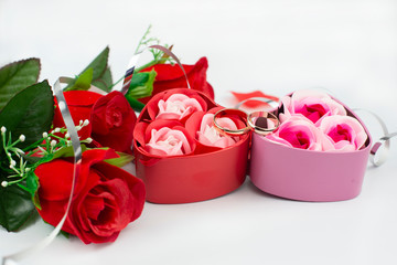 box surprise gift pink with bow with wedding rings on a white background with roses for Valentine's day