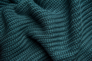 Texture of a woolen knitted green-blue sweater. Fabric turquoise background. Beautiful saturated...