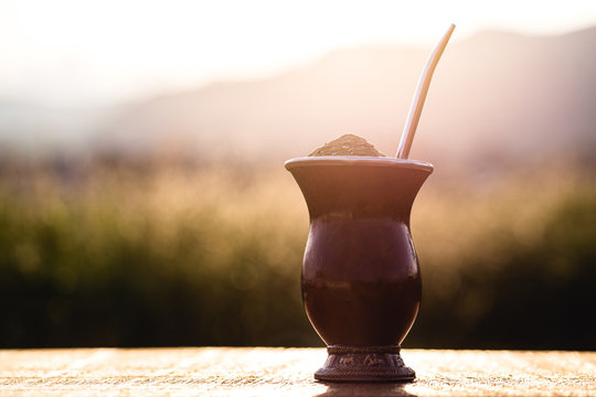 Gaucho yerba mate tea, the chimar&atilde;o, typical brazilian drink, traditionally in a cuiade bombilla stick gourd against wooden background. Rio Grande do Sul, preferred drink of the gauchos.