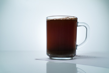 transparent cup with natural coffee on a light background with free space for text