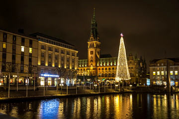 Night view of Binnenalster lake and Christmas market at Town Hall square near Hamburg Town Hall (Hamburg Rathaus), Germany. Christmas tree on the square