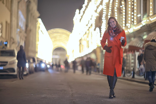winter night in the city lights / adult girl in a coat walk in the city, fashionable stylish image of a beautiful model