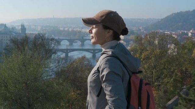 Enjoy the view of the bridges. A cute girl tourist enjoys the autumn views of the Prague bridges.