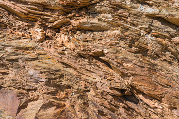 Natural background of brown layered sandstone. Rock on the seashore.