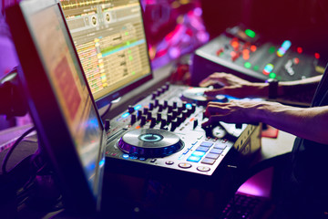 Fototapeta na wymiar Dj mixes the track in the nightclub at a party