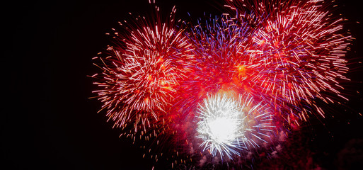 Large expanding red, white, blue,and gold starburst fireworks with a black background