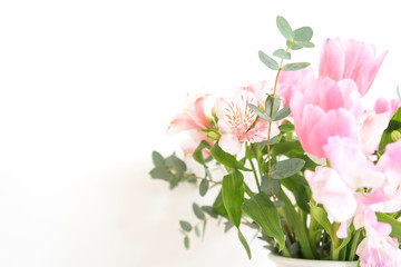 ピンク系の花とグリーン　花　植物　アップ　　ピンク　グリーン　白い花瓶とピンク系の花　おしゃれ　アレンジ　春　季節　自然光　光　明るい　白い壁　白背景　フラワーアレンジメント　インテリア写真　春の花　家　白バック