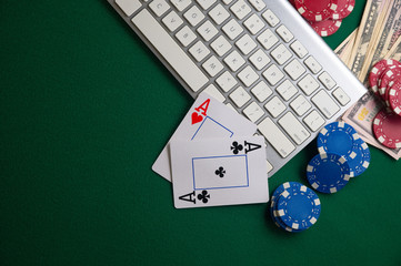 Online Poker Chips and Dice Near Keyboard on Gaming Green Table Top Copyspace