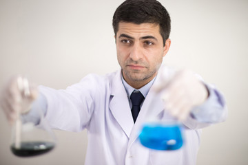 A male scientist wears a white robe and is excited about his research in the laboratory.