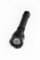 black pocket flashlight with zoom focus lens, white background