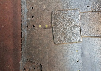 Surface of an iron plate with some holes on it.