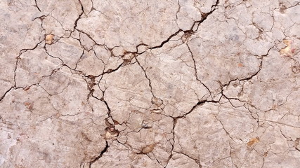 Broken or macro cracked. Photo of  soil during drought background. Hard shadows and  dried ground...