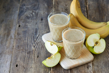 Banana smoothie with green apples on a wooden table