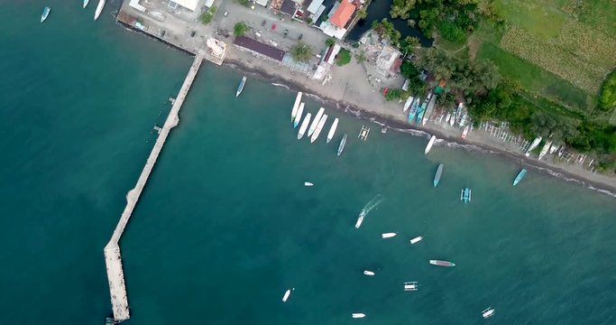 Aerial zoom in of beautiful blue ocean, beach and boats
