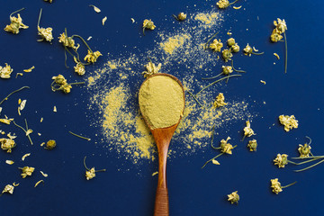 Close up of Ingredients of ayurvedic treatment or face pack. Dried chamomile and yellow clay on a...