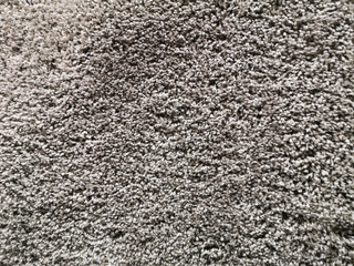 Dense and wrinkled texture of a gray carpet with a thick pile. carpet background