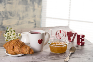 coffee and croissant with gifts in heart
