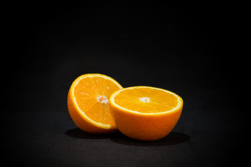 Sliced orange fruit on black background