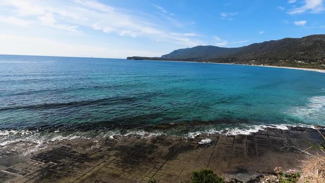 view of the landscape and coastline at the Tessalated Pavement beach in Eaglehack Neck in the Tasman Peninsula in Tasmania, camera panning horizontally
