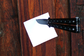A message left by the robber on the door of the house. A knife stuck in the wall with a piece of...
